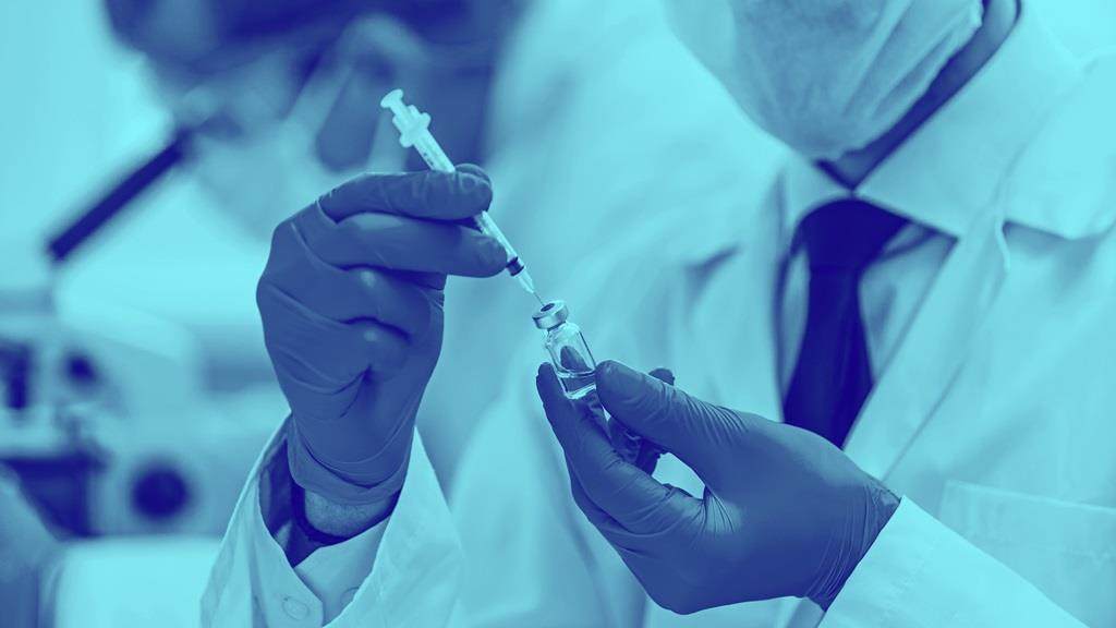Blue washed image of vaccine being drawn from glass bottle